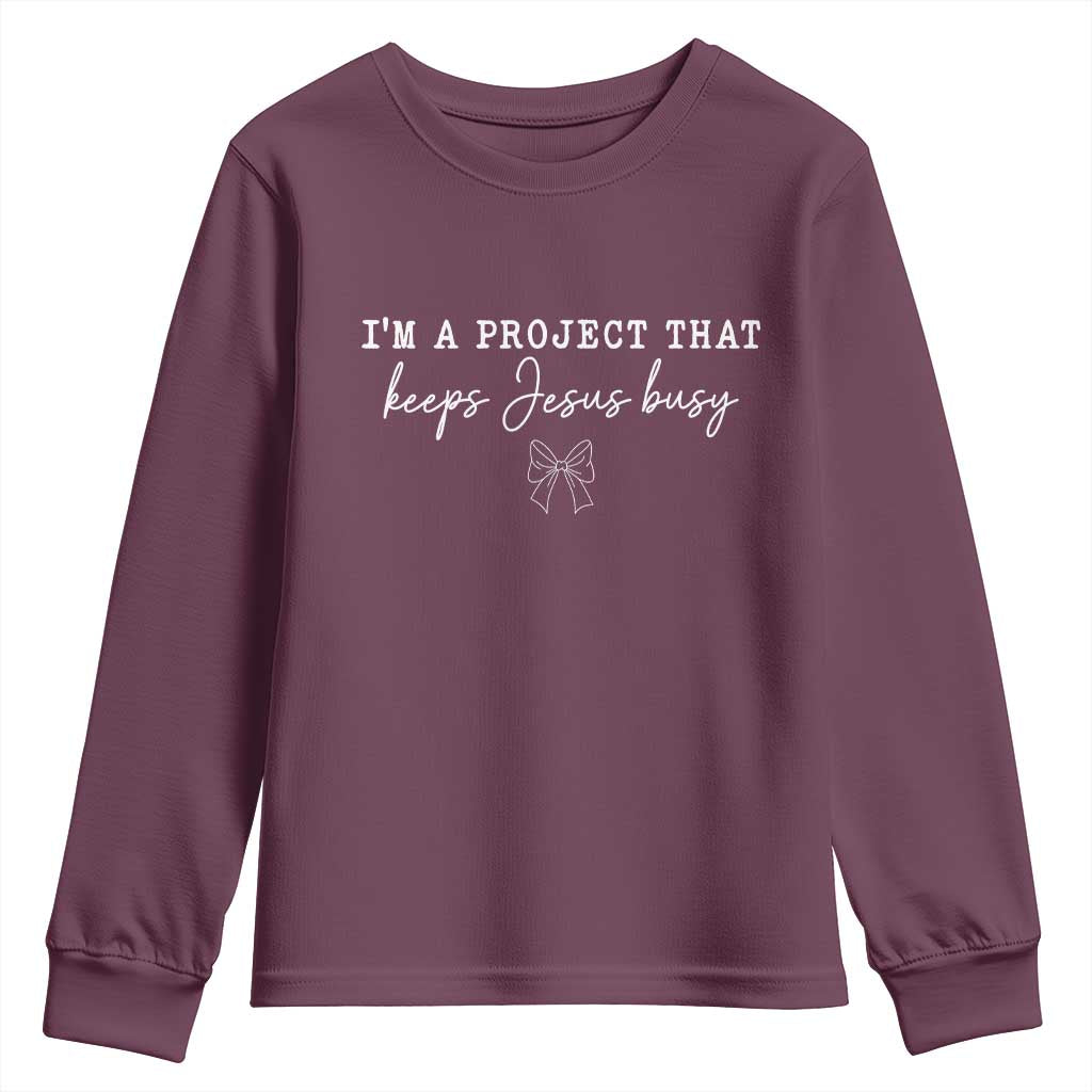 I am a Project That Keeps Jesus Busy Coquette Bow Youth Sweatshirt Christian Faith Humor TS02 Maroon Print Your Wear