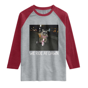We Ride at Dawn Raglan Shirt Funny Racoon Riding Tricycle Chaotic Meme