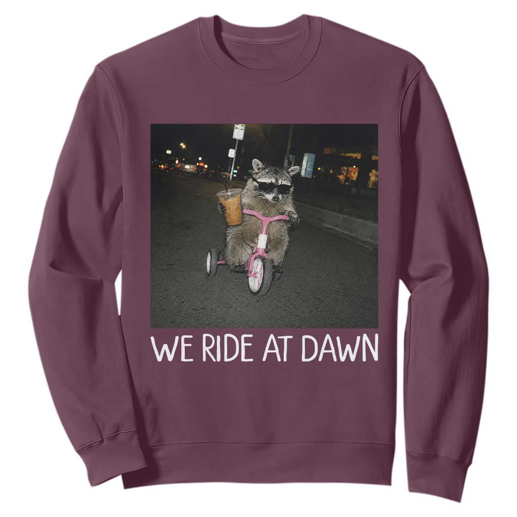 We Ride at Dawn Sweatshirt Funny Racoon Riding Tricycle Chaotic Meme